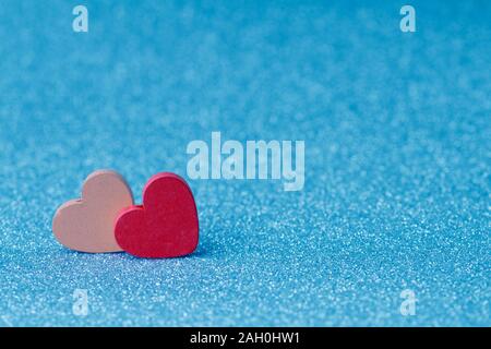 Pink and red wooden  hearts on a blue background. Valentine`s day holiday card Stock Photo